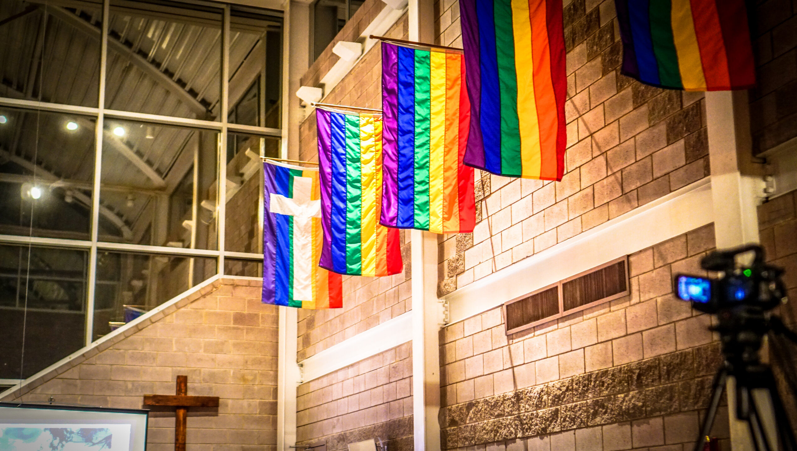 Pride flags displayed inside an affirming Christian worship space